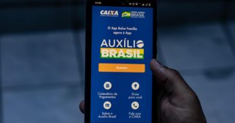 Auxílio Brasil: celular mostrando logo do benefício