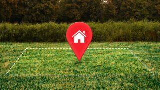 Empréstimo com garantia: imagem mostra um terreno gramado, com uma demarcação em linhas pontilhadas. No centro há um marcador com a ilustração de uma residência.