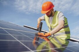 homem instalando painéis de energia solar (financiamento para energia solar)