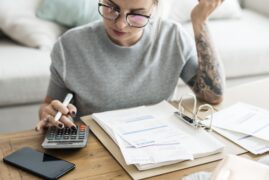 mulher calculando notas fiscais (declarar imposto de renda)