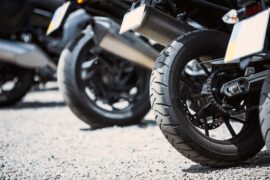 Empréstimo com garantia de moto: diversas motocicletas estão alinhadas e a imagem mostra apenas o pneu traseiro e placa.