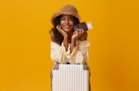 Mulher com mala e passagens na mão (Dia Nacional do Turismo)