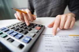 pessoa usando calculadora (faixa de isenção do Imposto de Renda)
