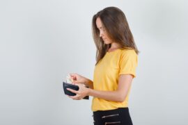 Mulher colocando dinheiro na carteira (saque extraordinário)