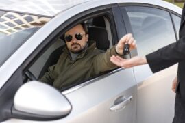 homem dentro de carro entregando chave (vender um carro financiado)