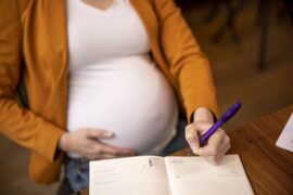 mulher gravida fazendo anotações (licença-maternidade)