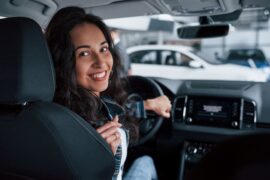 Mulher fazendo teste em carro (financiamento de veículo)